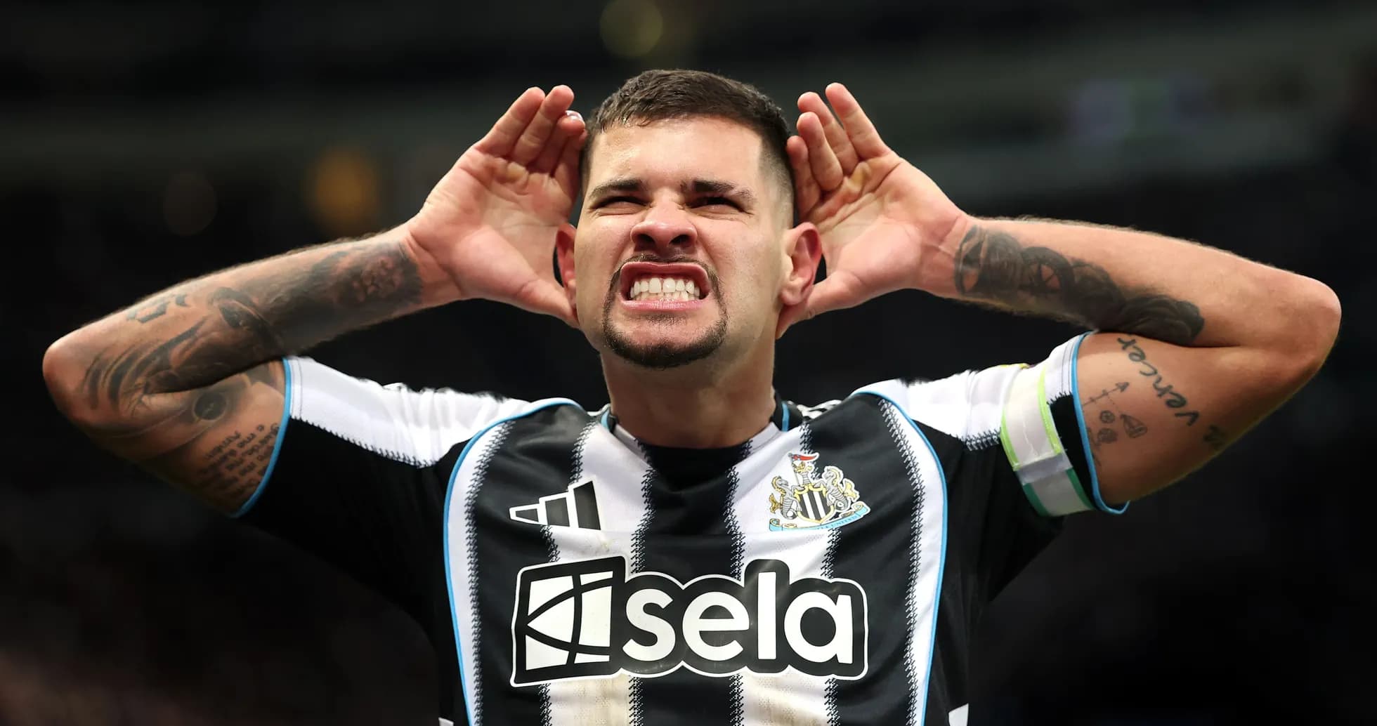 Игрок Newcastle United поднимает руки к ушам на поле