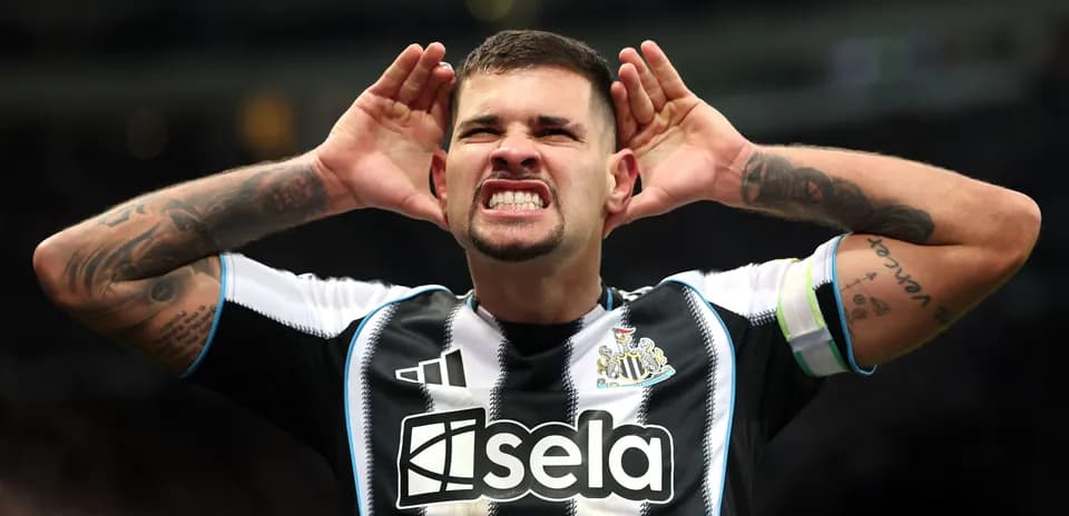 Игрок Newcastle United поднимает руки к ушам на поле