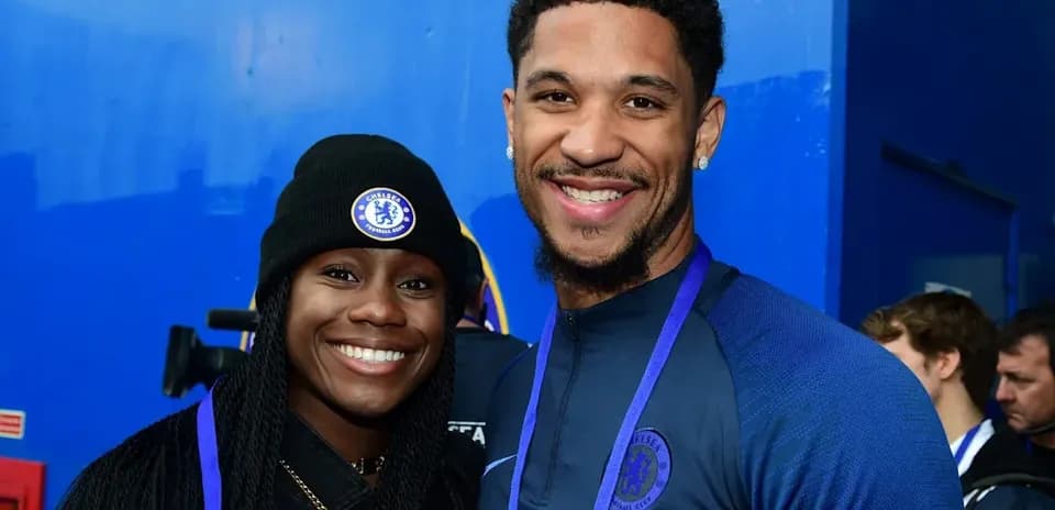 Два человека в одежде Chelsea улыбаются на фоне