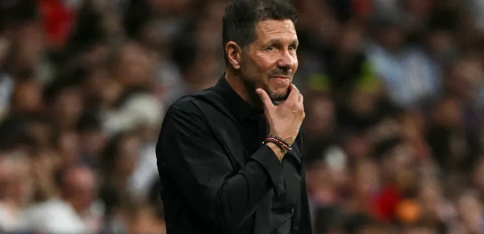 Тренер на скамейке, задумчиво смотрит на поле