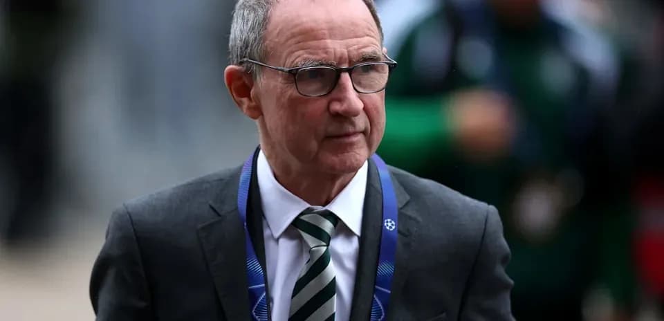 Тренер в костюме на стадионе перед матчем