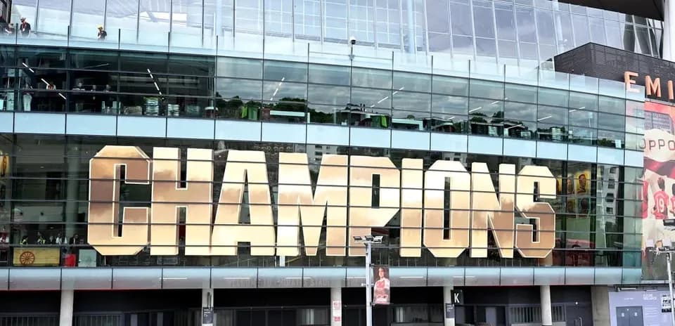 Здание с надписью 'CHAMPIONS' на фасаде стадиона