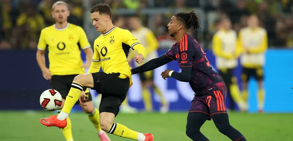 Игроки Borussia Dortmund и соперник борются за мяч