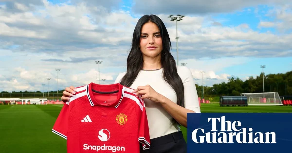 Женщина держит футболку Manchester United на тренировочном поле