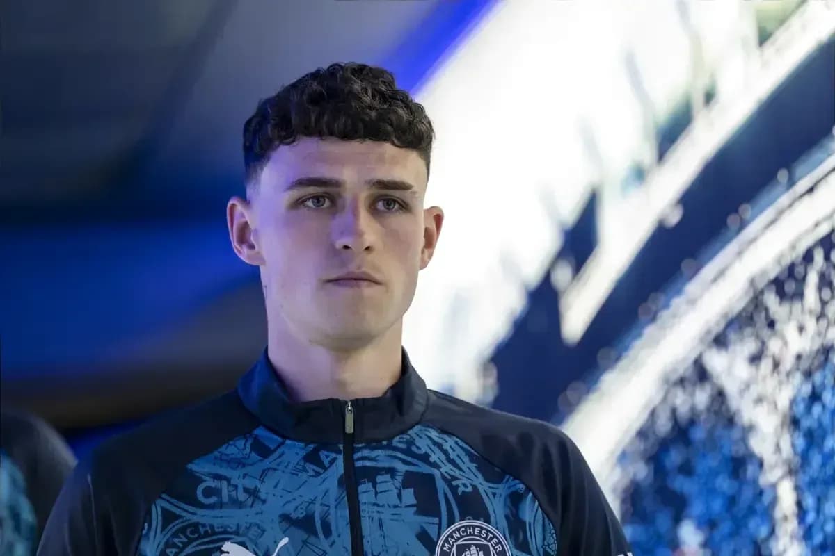Игрок Manchester City на фоне клубного логотипа