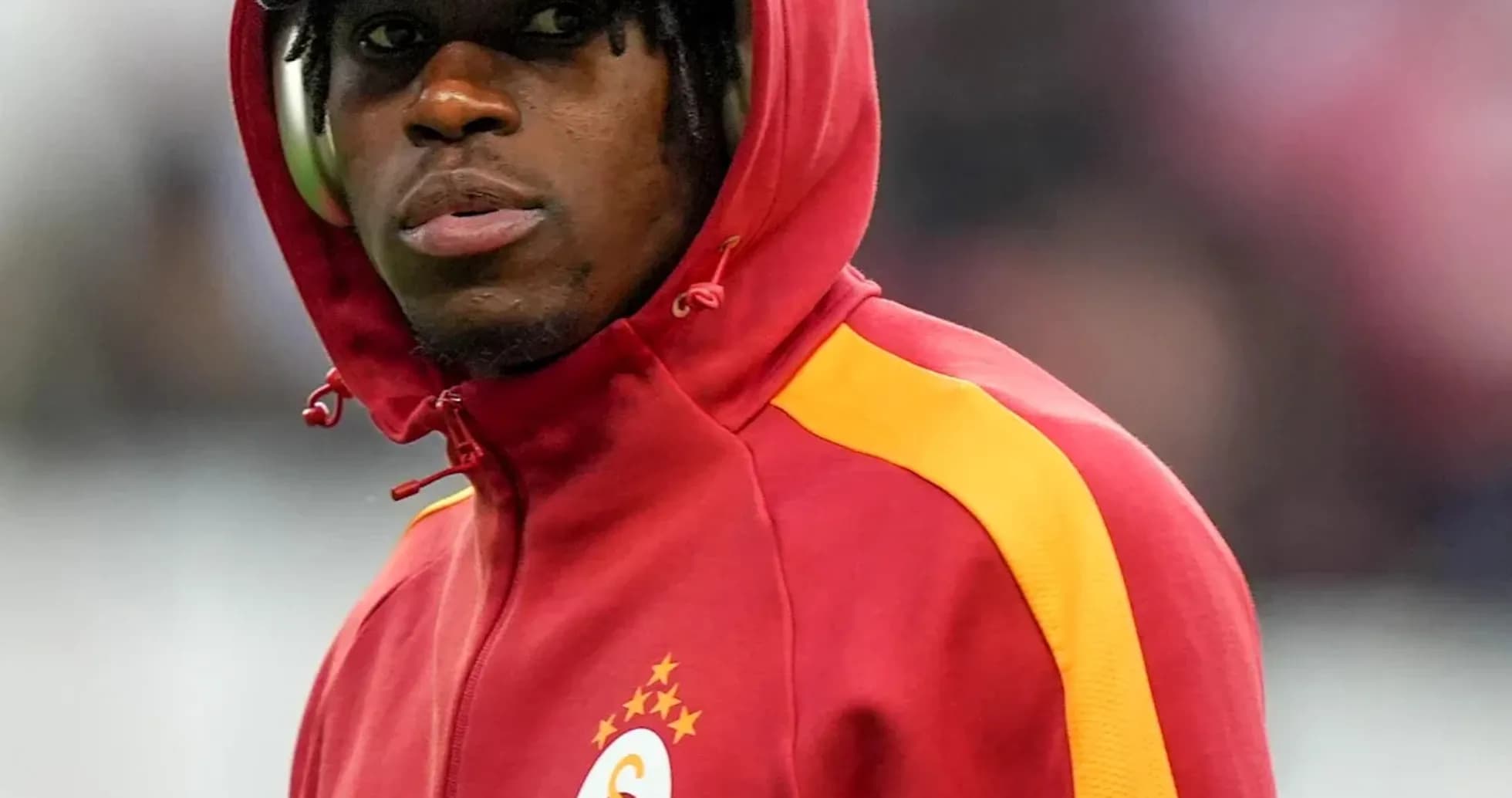 Игрок в красной куртке Galatasaray на поле