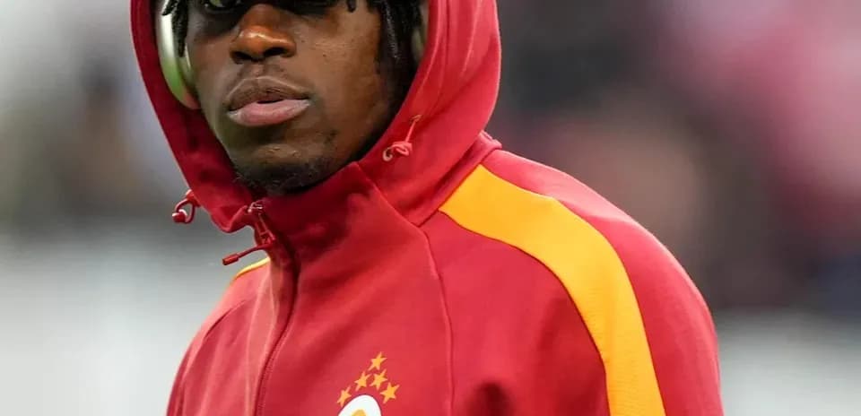 Игрок в красной куртке Galatasaray на поле
