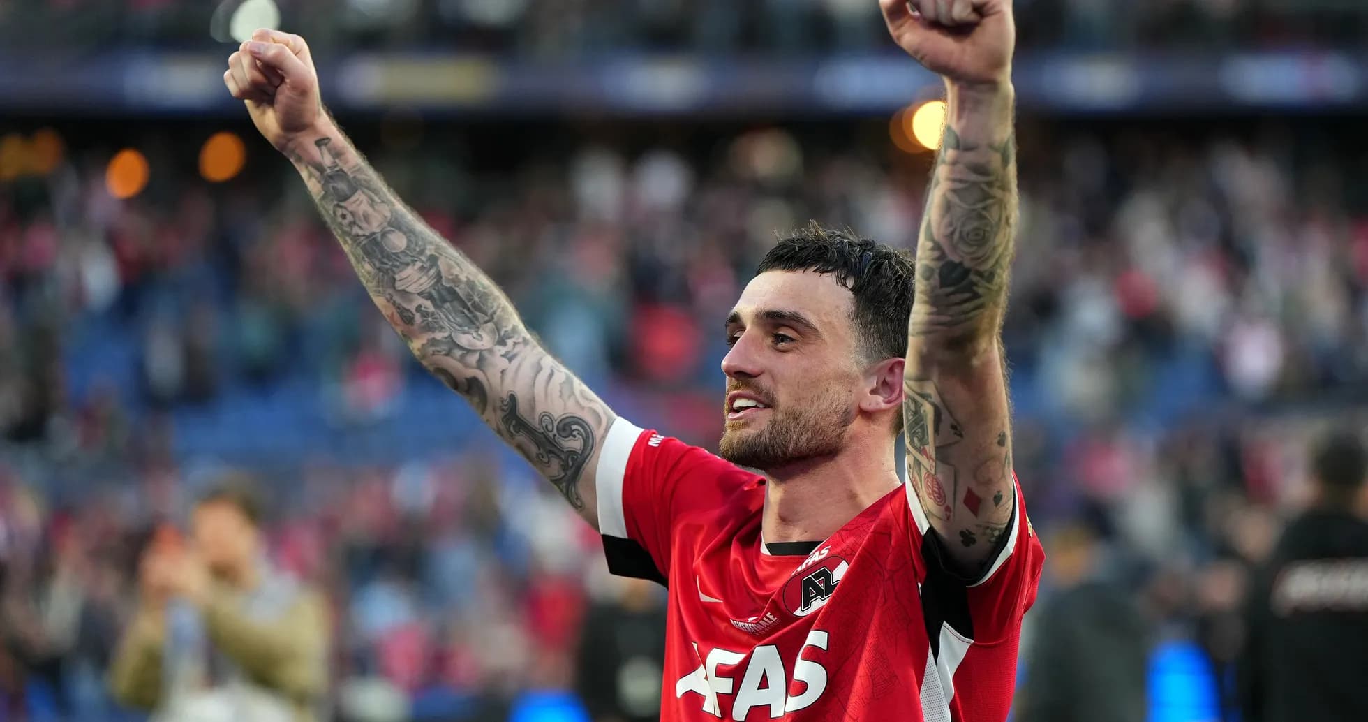 Игрок AZ Alkmaar празднует победу с поднятыми руками