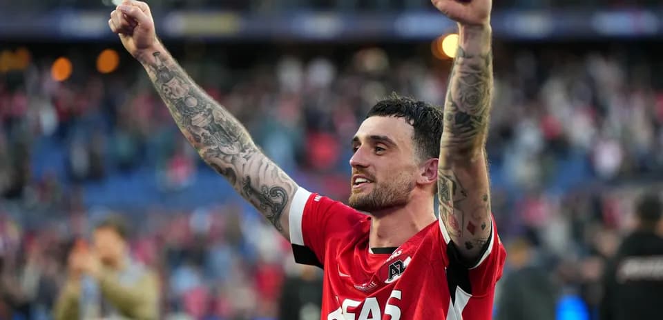 Игрок AZ Alkmaar празднует победу с поднятыми руками