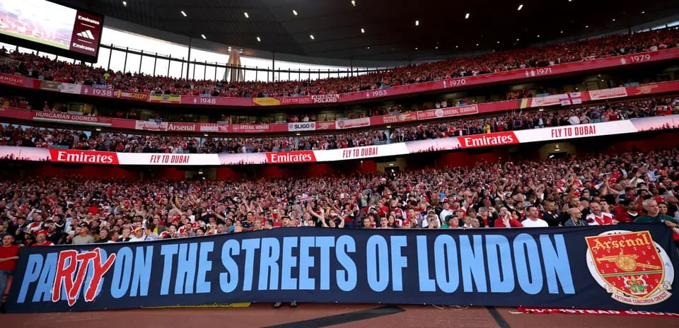 Фанаты Arsenal с баннером на стадионе Emirates