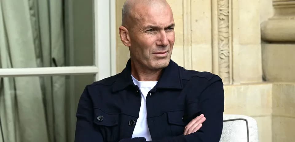 Зинедин Зидан сидит с перекрещёнными руками