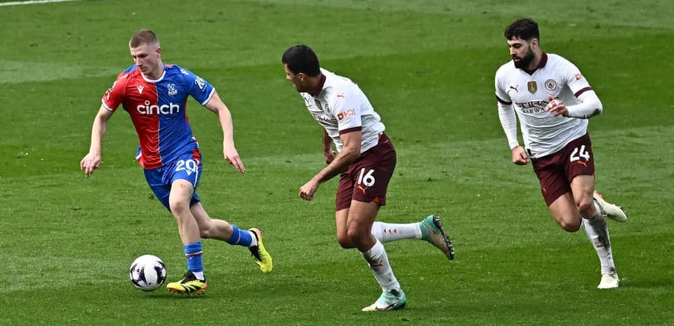 Игрок Crystal Palace ведет мяч, два защитника преследуют