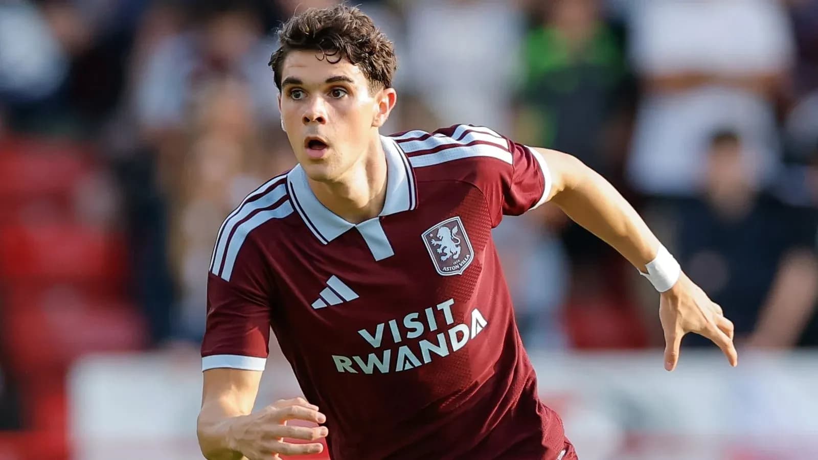 Игрок Aston Villa бежит по полю во время матча