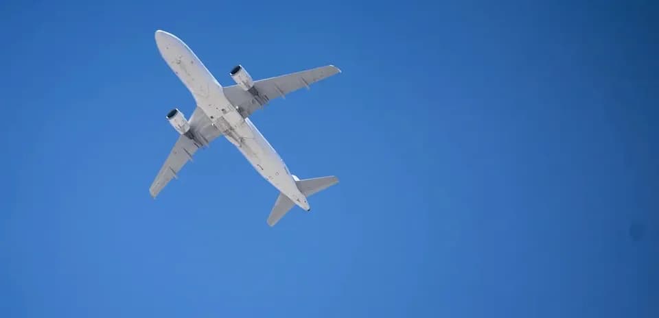Самолет летит высоко в ясном небе