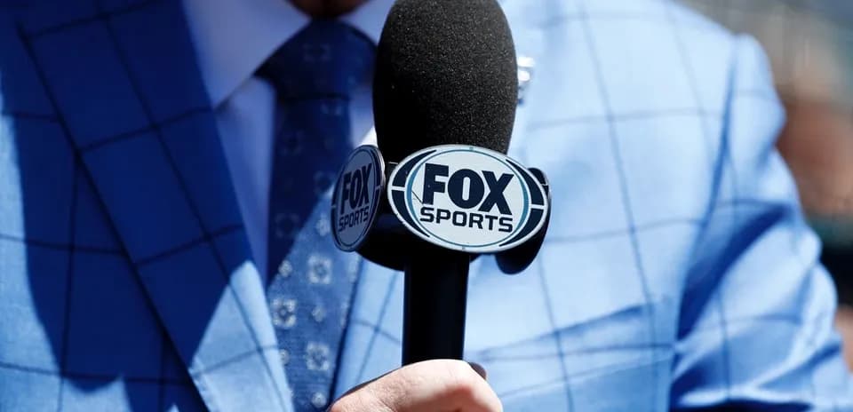 Микрофон Fox Sports в руке человека в костюме