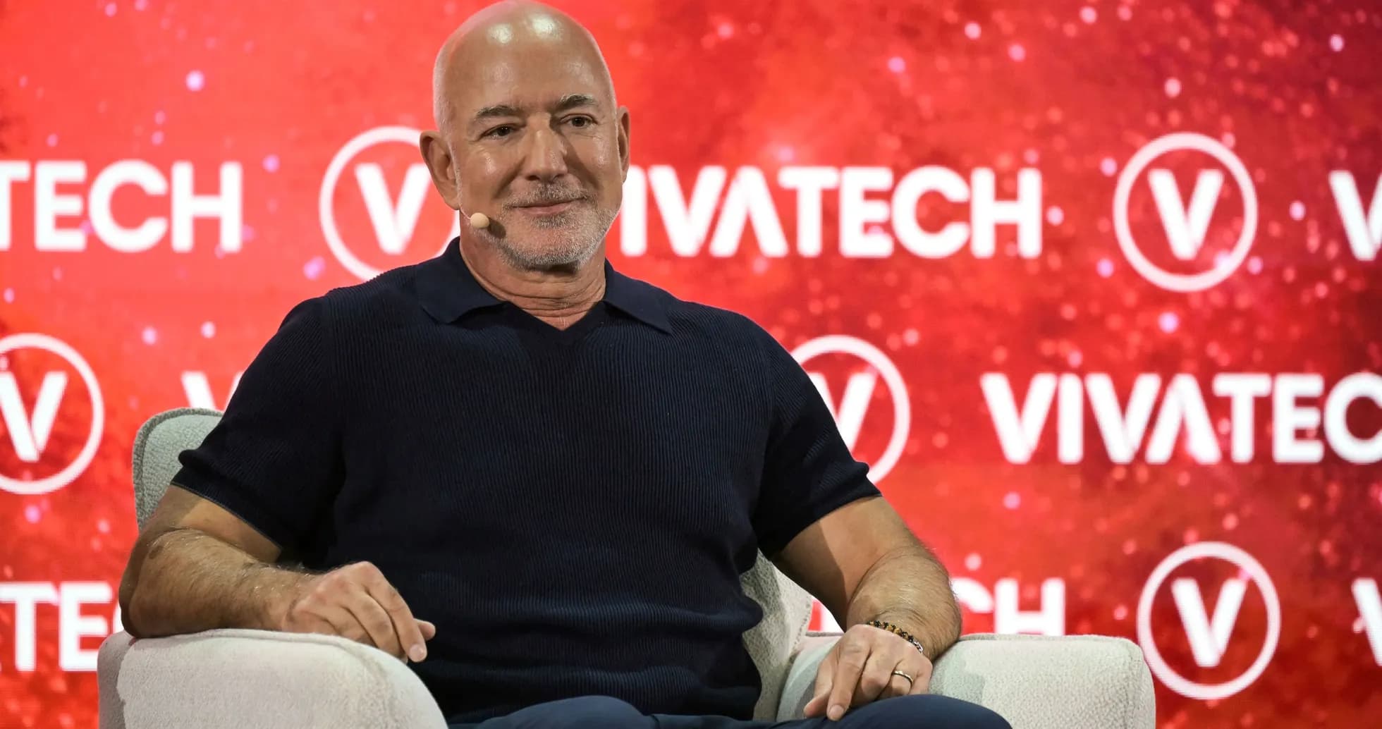 Человек сидит на сцене с логотипом Vivatech