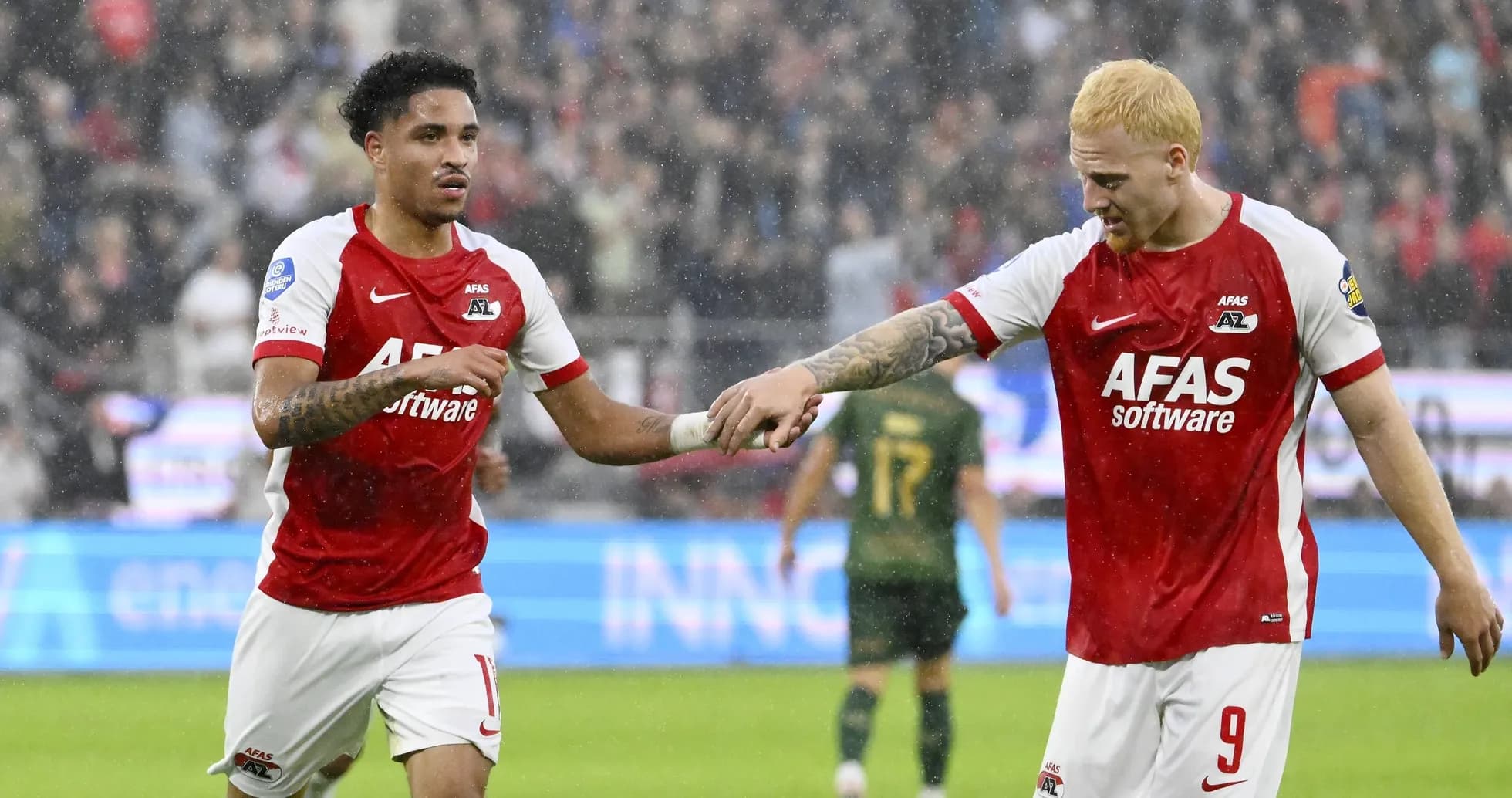 Игроки AZ Alkmaar празднуют гол под дождем