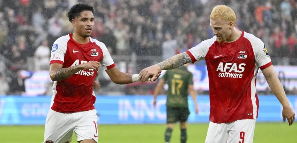 Игроки AZ Alkmaar празднуют гол под дождем