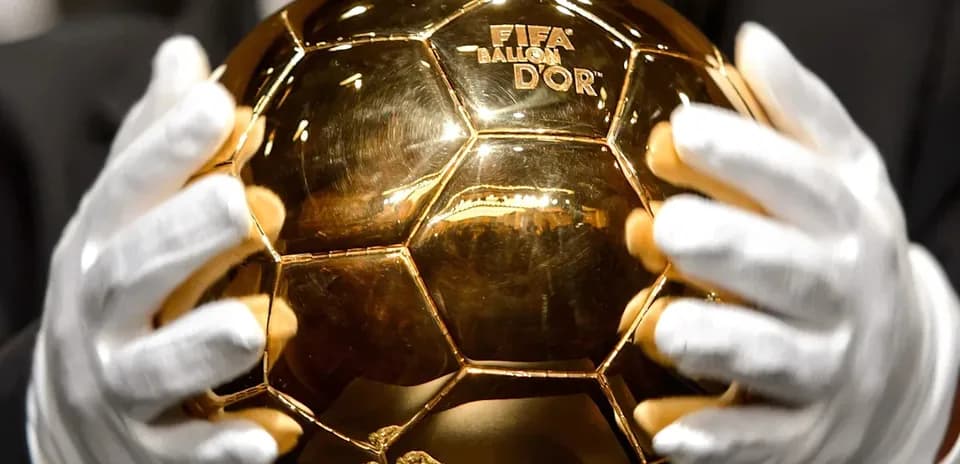 Человек держит Золотой мяч FIFA в руках