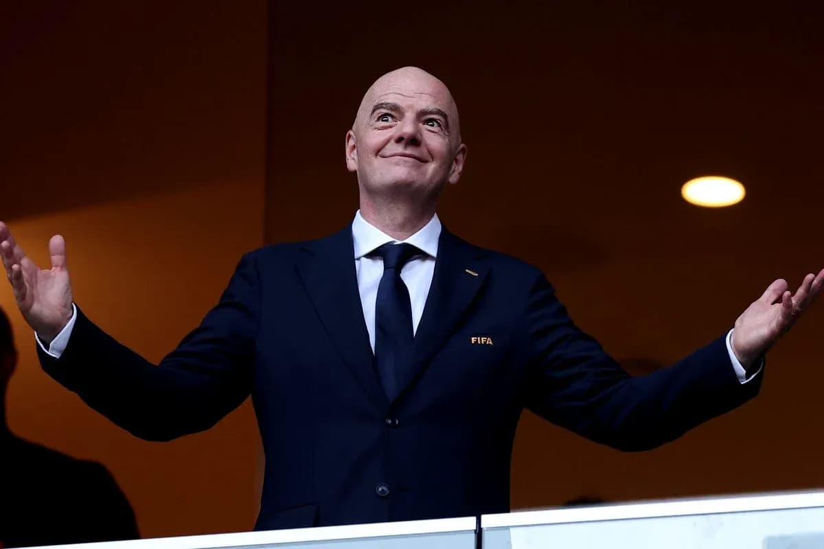 Человек в костюме с логотипом FIFA на трибуне