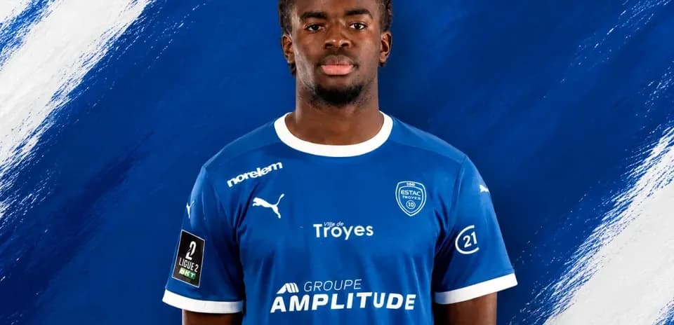 Игрок в синей форме ESTAC Troyes на фоне