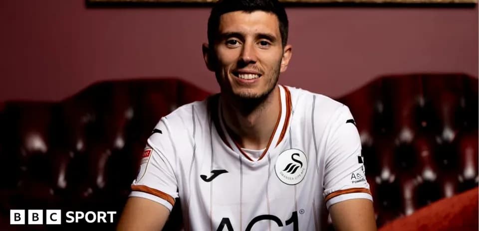 Игрок в форме Swansea City сидит на диване