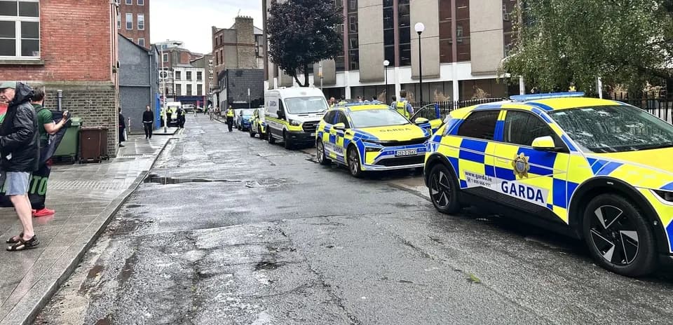 Полицейские машины Garda на улице во время операции