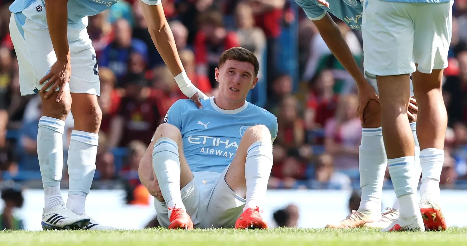 Игрок Manchester City сидит на поле с травмой