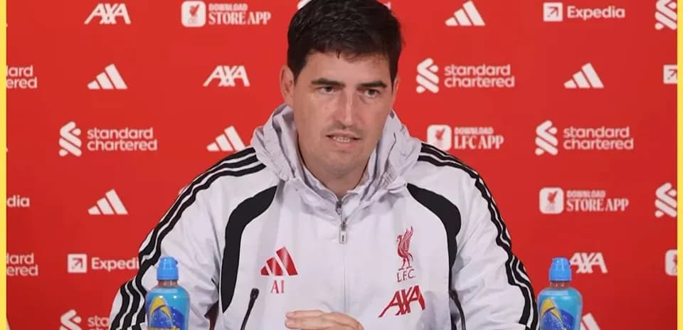 Тренер на пресс-конференции с логотипом Liverpool