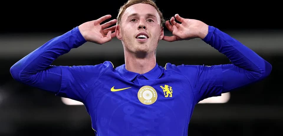 Игрок в синей форме Челси с руками у ушей