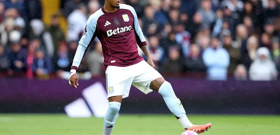 Игрок Aston Villa готовится ударить мяч на поле