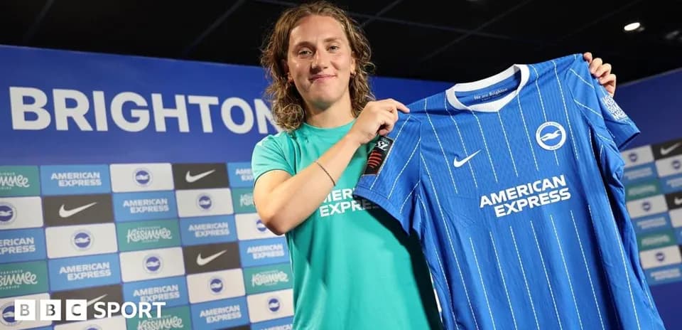 Игрок держит футболку Brighton на пресс-конференции