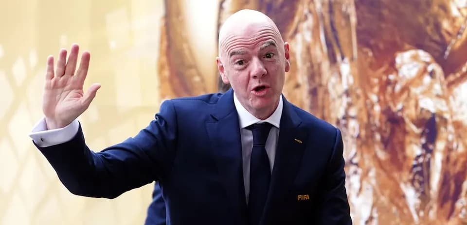 Человек в костюме с логотипом FIFA, приветствует