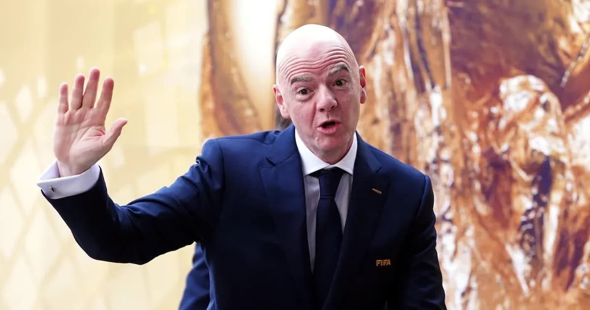 Человек в костюме с логотипом FIFA, приветствует