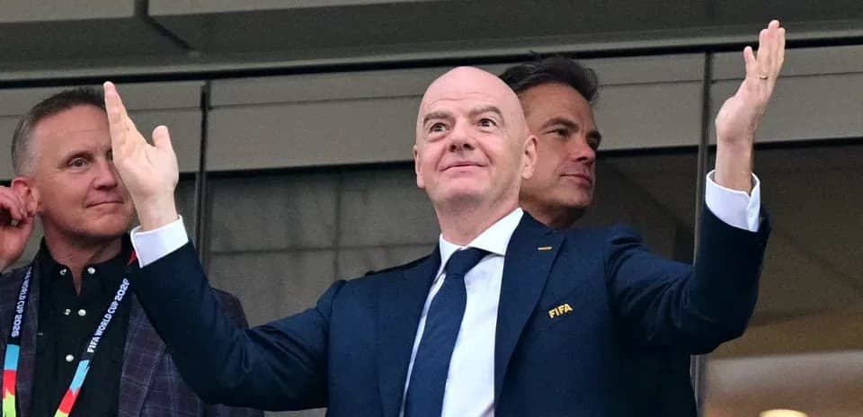 Функционер FIFA с поднятыми руками на трибуне
