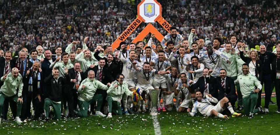 Команда Aston Villa празднует победу с трофеем