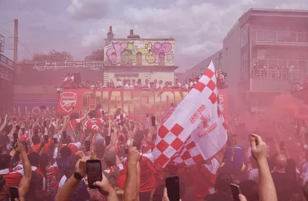 Фанаты Arsenal празднуют победу с флагами и дымом