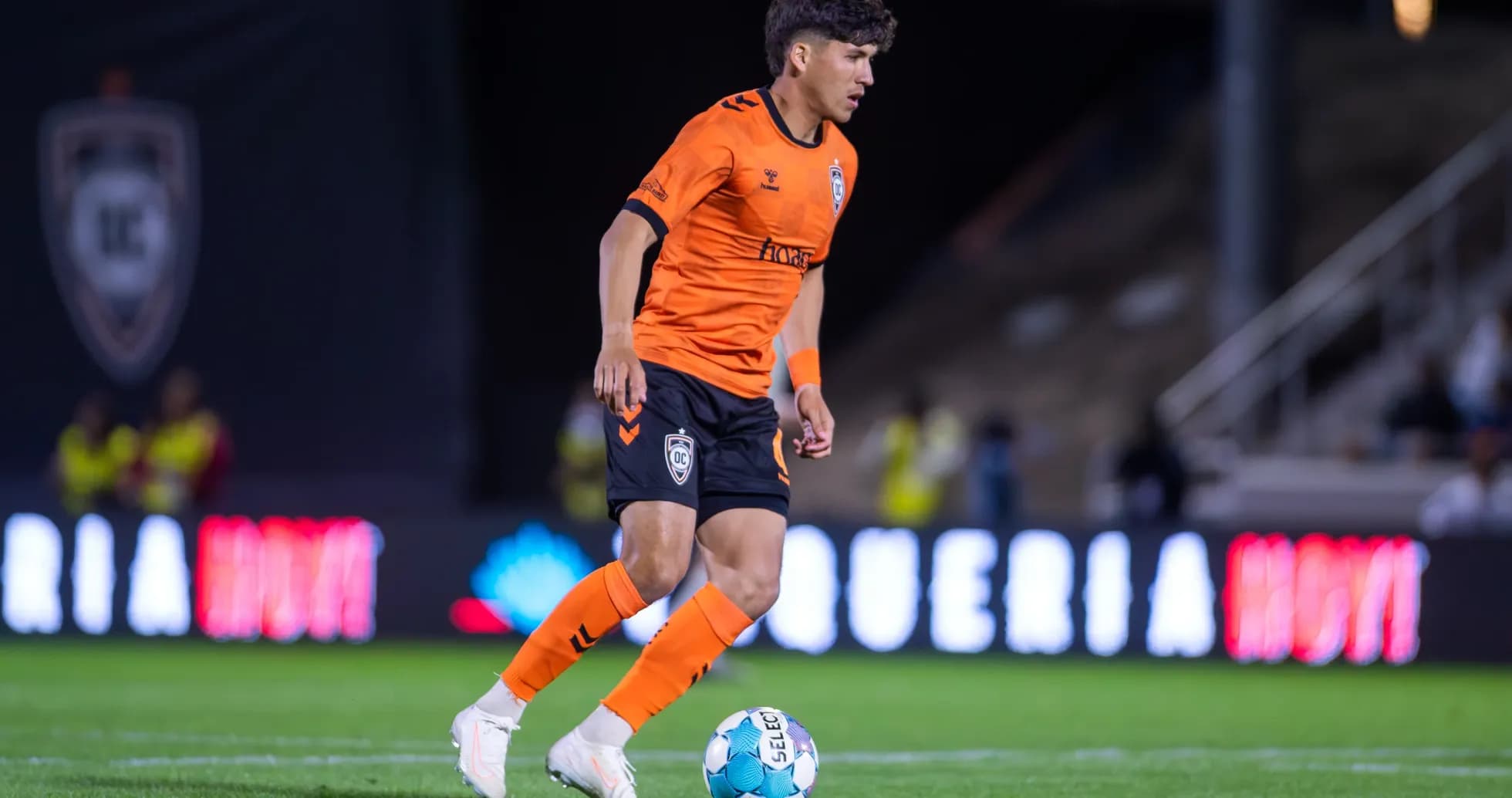 Игрок Orange County SC с мячом на поле Игрок Orange County SC с мячом на поле