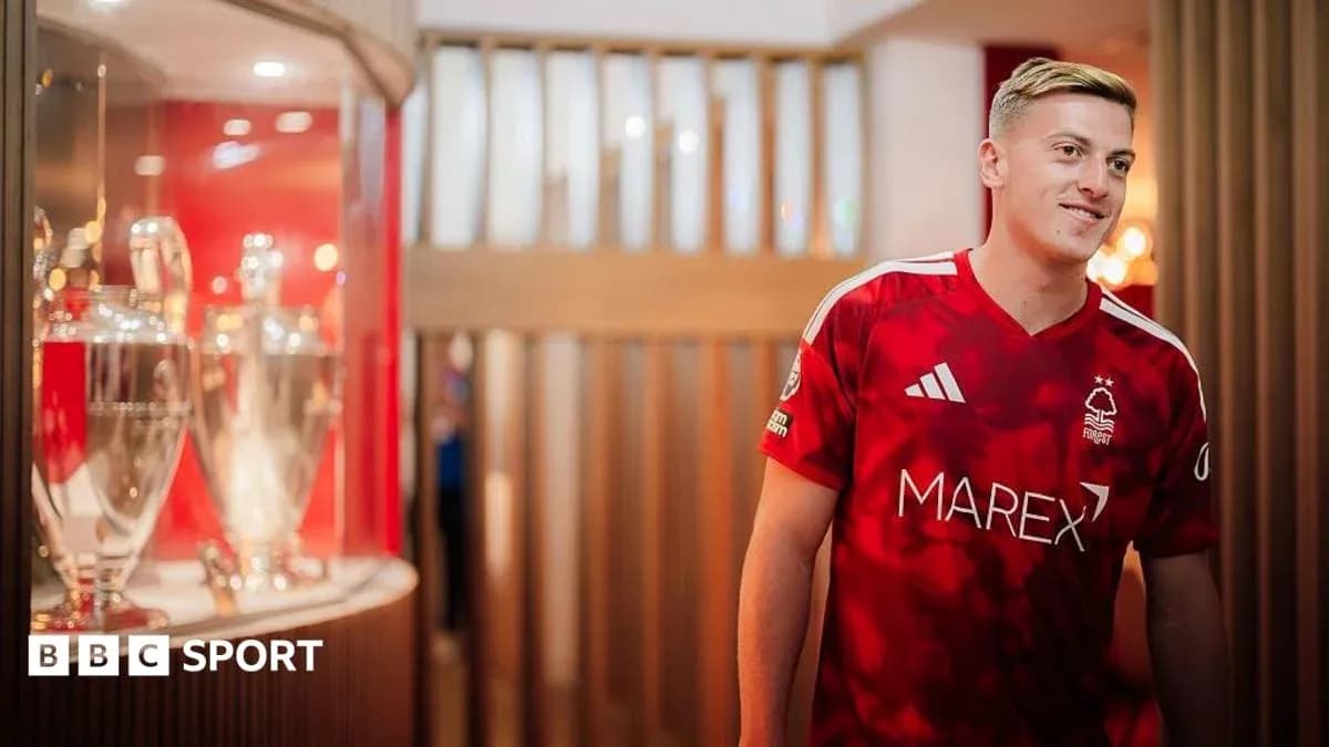 Игрок в красной форме Nottingham Forest с трофеями Игрок в красной форме Nottingham Forest с трофеями