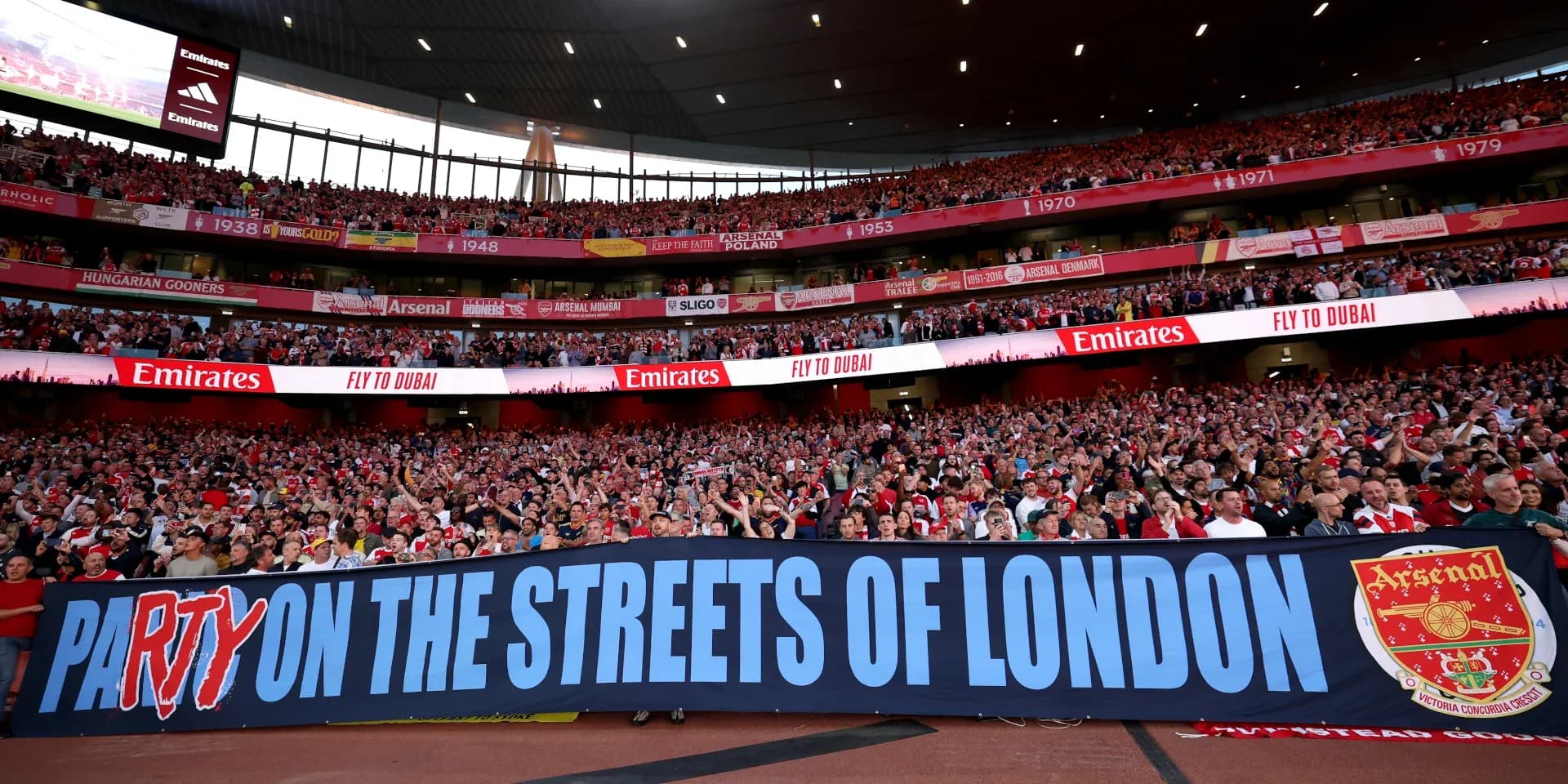 Фанаты Arsenal с баннером на стадионе Emirates Фанаты Arsenal с баннером на стадионе Emirates