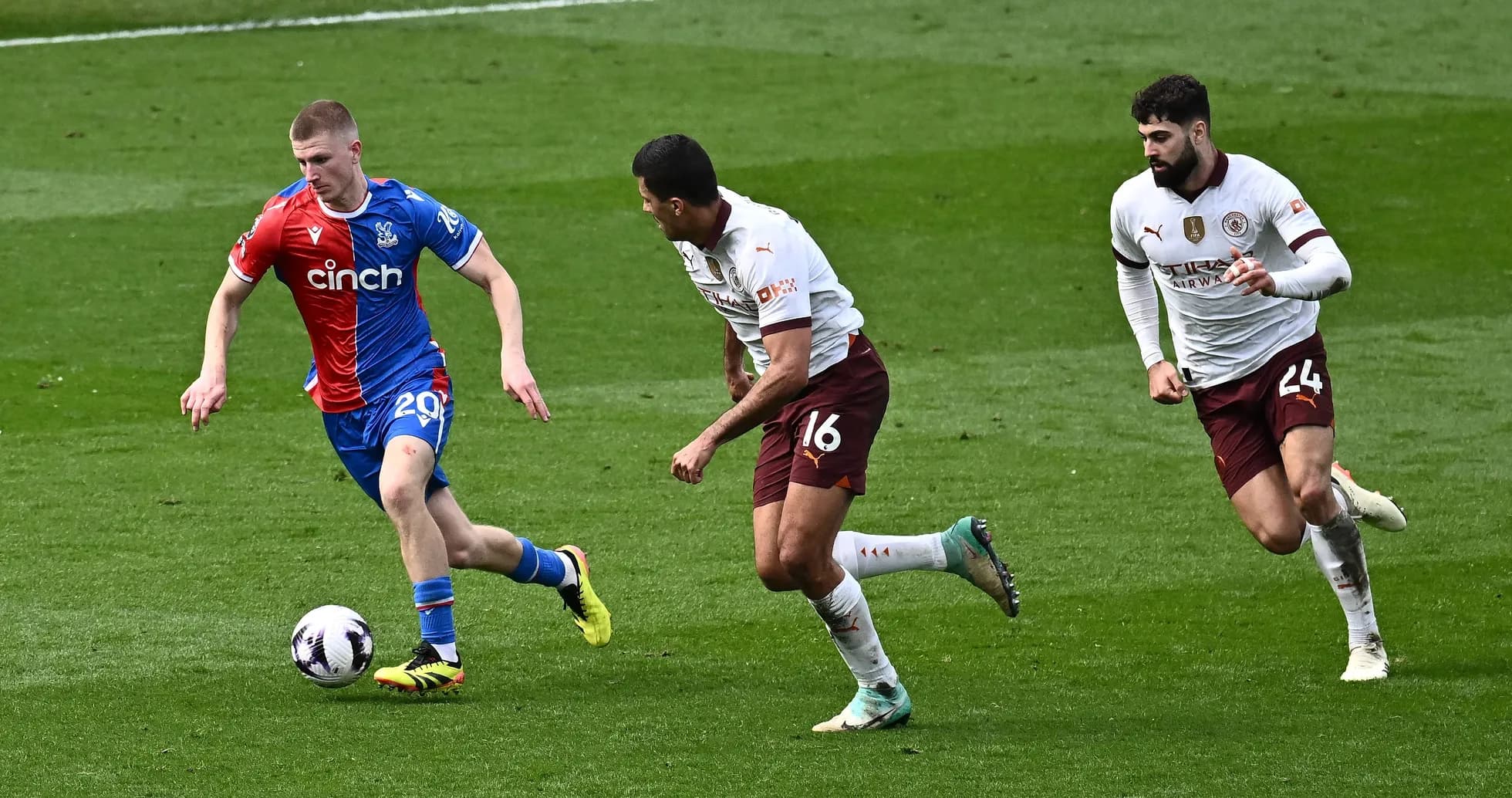 Игрок Crystal Palace ведет мяч, два защитника преследуют Игрок Crystal Palace ведет мяч, два защитника преследуют
