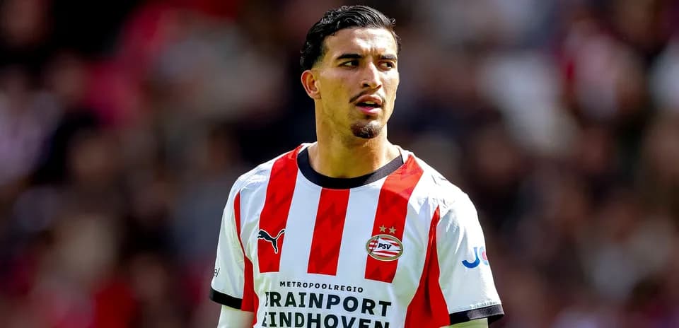 Игрок PSV в красной и белой форме на поле Игрок PSV в красной и белой форме на поле