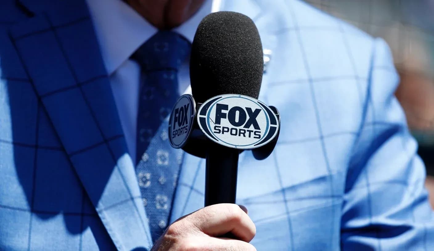 Микрофон Fox Sports в руке человека в костюме Микрофон Fox Sports в руке человека в костюме
