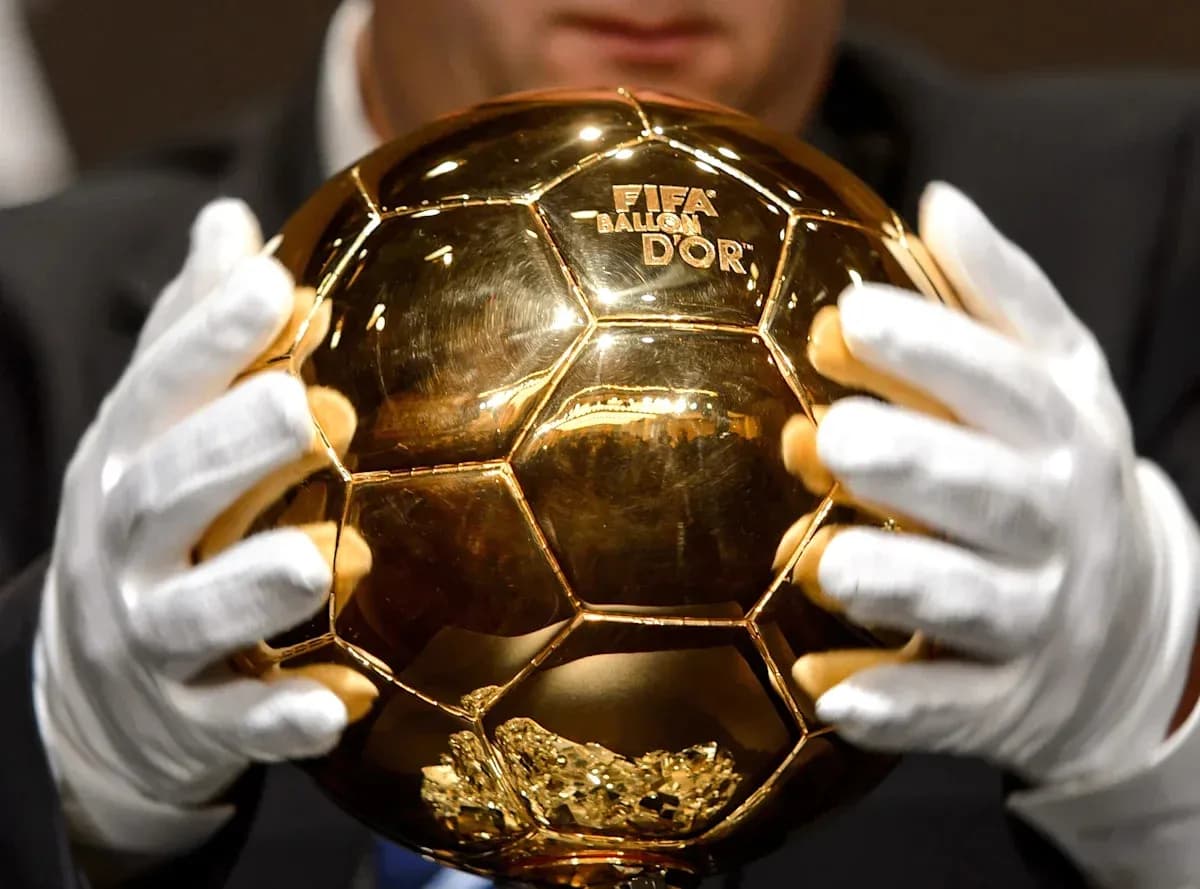 Человек держит Золотой мяч FIFA в руках Человек держит Золотой мяч FIFA в руках